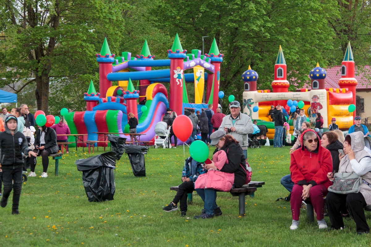 Family Relaxing At Outdoor Summer Event. Crowds of diverse people sitting in the park